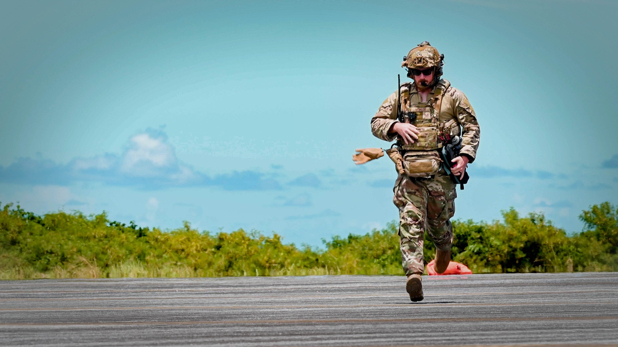 A landing zone saftey officer runs across the airfield.