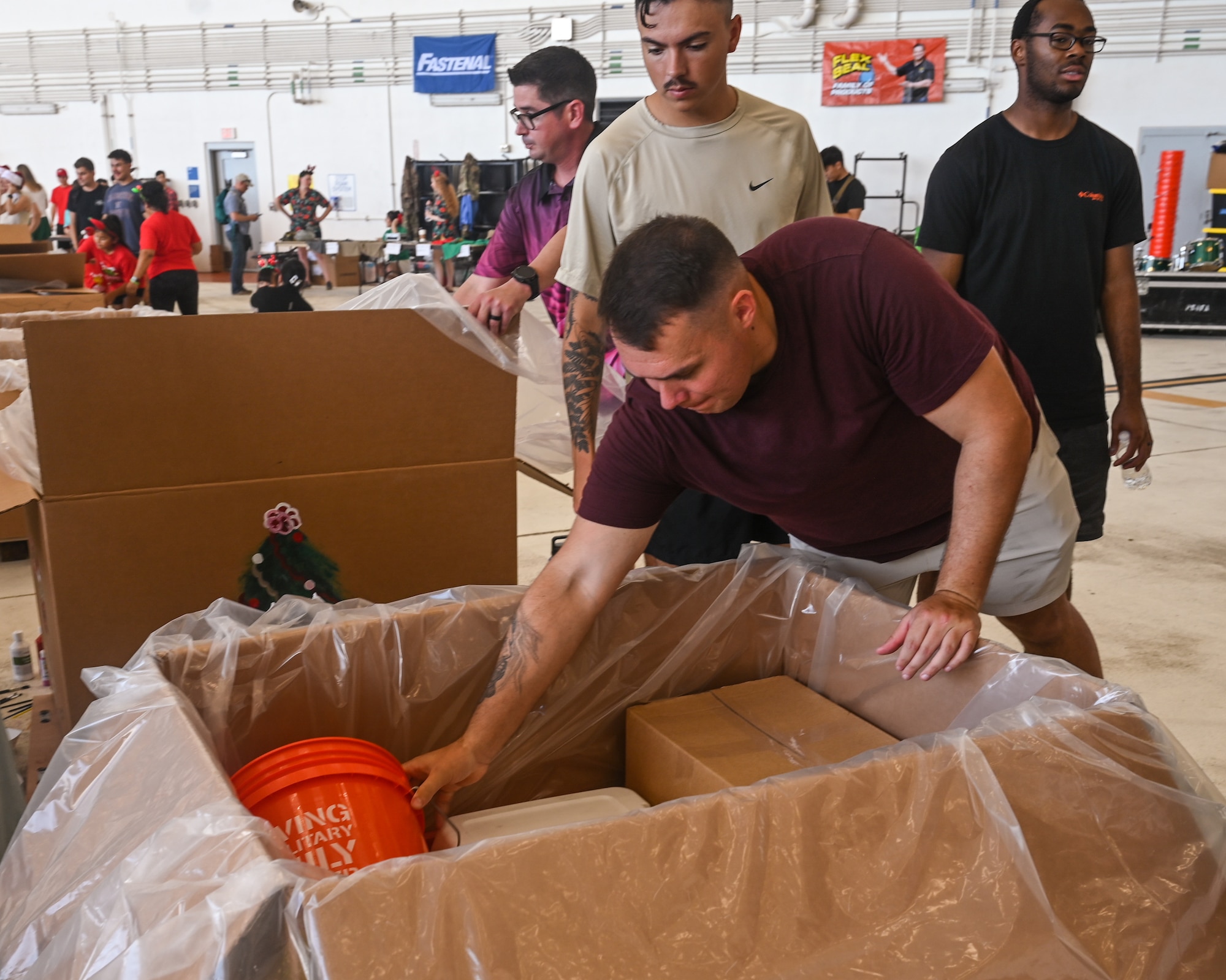 Senior Airman Colby Fox, a response force leader for 11th Combat Air Base Squadron, places books in their unit bundle during Operation Christmas Drop 2025 at Andersen Air Force Base, Guam, Dec. 6, 2025.