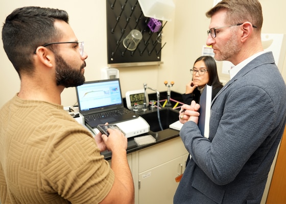 JOINT BASE SAN ANTONIO-FORT SAM HOUSTON (Dec. 8, 2025) Research scientist Juan Curbelo (left) and research immunologist Dr. Dao Ho assigned to Naval Medical Research Unit (NAMRU) San Antonio’s Combat Casualty Care and Operational Medicine directorate, explain the cell-based, in vitro platforms used to test the safety and efficacy of the Defense Advanced Research Projects Agency’s (DARPA) Fieldable Solutions for Hemorrhage with bio-Artificial Resuscitation Products (FSHARP) program’s novel synthetic blood product to Dr. Jeremy Pamplin, program manager, DARPA’s Biological Technologies Office at the Battlefield Health & Trauma Research Institute. The FSHARP program works to develop a deployable, shelf-stable, universal whole blood substitute as a hemorrhage countermeasure to sustain injured warfighters in austere, pre-hospital settings. NAMRU San Antonio serves as the Independent Validation & Verification partner for the FSHARP program to perform laboratory testing for safety and efficacy. The platforms used by NAMRU San Antonio incorporate both 2D and 3D formats, thus allowing the research scientists to assess endothelial barrier function in models that mimic the form and function of tubular blood vessels, which is translational to human physiology. NAMRU San Antonio, part of Navy Medicine Research & Development, works alongside research partners in the civilian sphere, academia, industry, and other government agencies to drive support of the Department of War’s objectives for a lethal fighting force and ensures U.S. service members have access to the latest scientific advances. NAMRU San Antonio conducts gap-driven combat casualty care, craniofacial, and directed energy research in support of Navy, Marine Corps and joint U.S. warfighter health readiness and lethality while engaged in routine and expeditionary operations. (U.S. Navy photo by Burrell Parmer/Released)