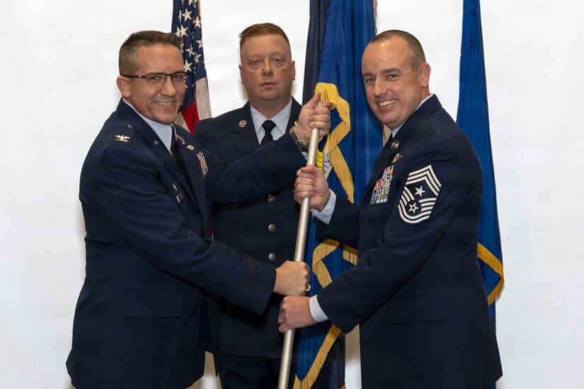 Col. Ryan D. Strong, left, 171st Air Refueling Wing commander, Pennsylvania Air National Guard, presents the 171st Air Refueling Wing guidon to Chief Master Sgt. Ryan Conley, incoming 171st ARW command chief, during an assumption of responsibility ceremony Dec. 6, 2025, near Pittsburgh, Pennsylvania. Upon assuming responsibility, Chief Conley is the 13th command chief of the unit. (U.S. Air National Guard photo by Tech. Sgt. Zoe M. Wockenfuss)