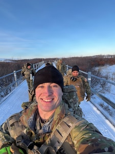 Alaska Army National Guard Spc. Brad Adams, assigned to the 297th Infantry Battalion’s Headquarters and Headquarters Company, and his team ruck march into town after landing in Tuntutuliak, Nov. 13, 2025, to support ongoing recovery operations following Typhoon Halong,