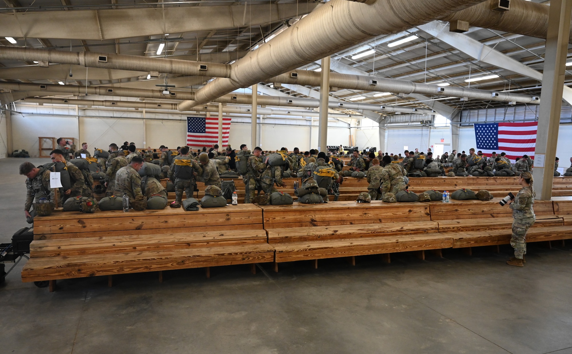 A group of paratroopers don parachutes.