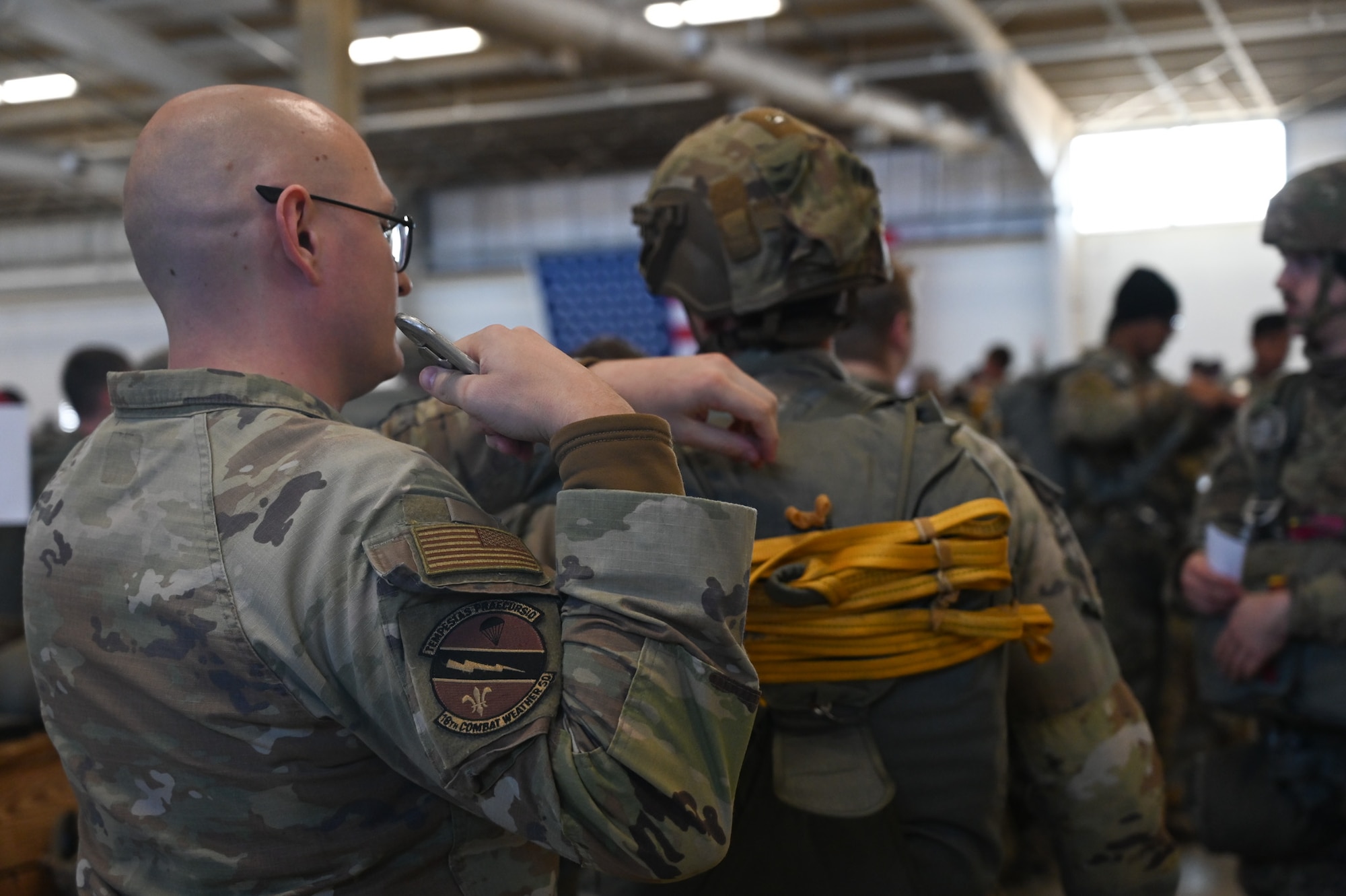An Airman check a parachute.