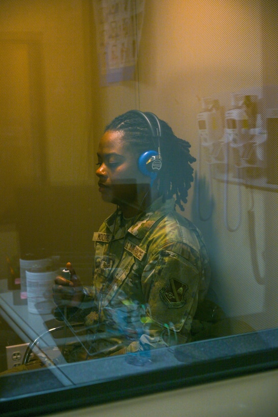 A service member sits in a hearing test booth