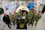 Captain Nichole Olson, Commanding Officer of the Navy Medicine Operational Training Command (NMOTC)(center right), presents the accreditation certificate to the Naval Aerospace Medical Institute (NAMI) Hyperbarics Team after they were awarded a Level-1 