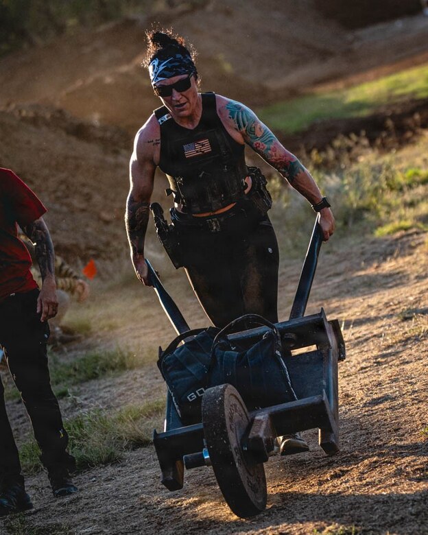 woman wearing workout gear pushes a cart.