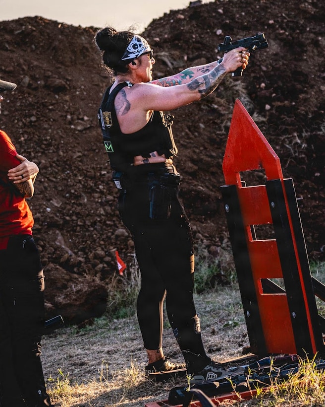 woman wearing workout gear shoots a pistol.