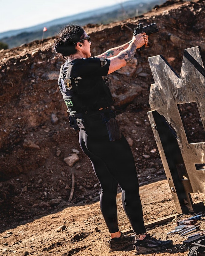 women wearing work out gear shoots a pistol.