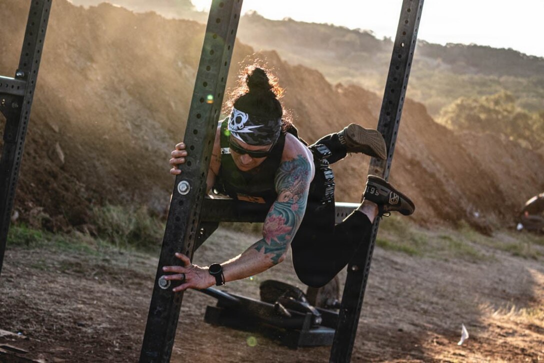 woman climbing over poles in a fitness challenge.