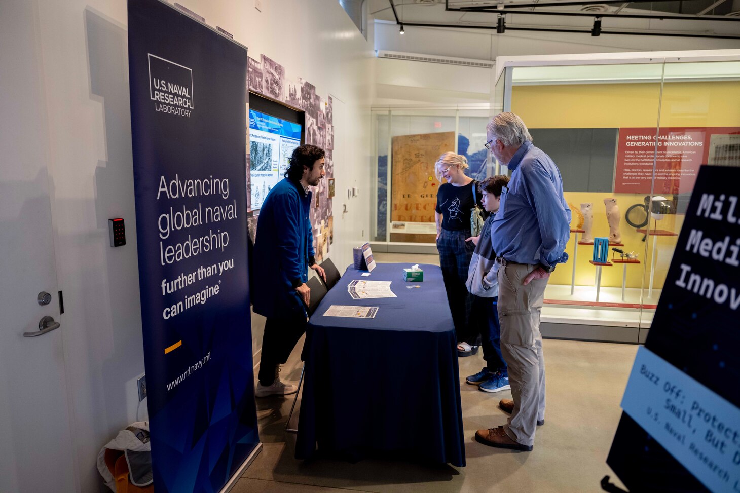Javier Jimenez (Left), U.S. Naval Research Laboratory research chemist, answers questions to attendees during Military Medical Innovation Family Program at the National Museum of Health and Medicine, in Silver Spring, MD, April 26, 2025. Jimenez worked on Designing thermoreversible gels for extended release of mosquito repellent. (U.S. Navy photo by Jonathan Steffen-Arnold)
