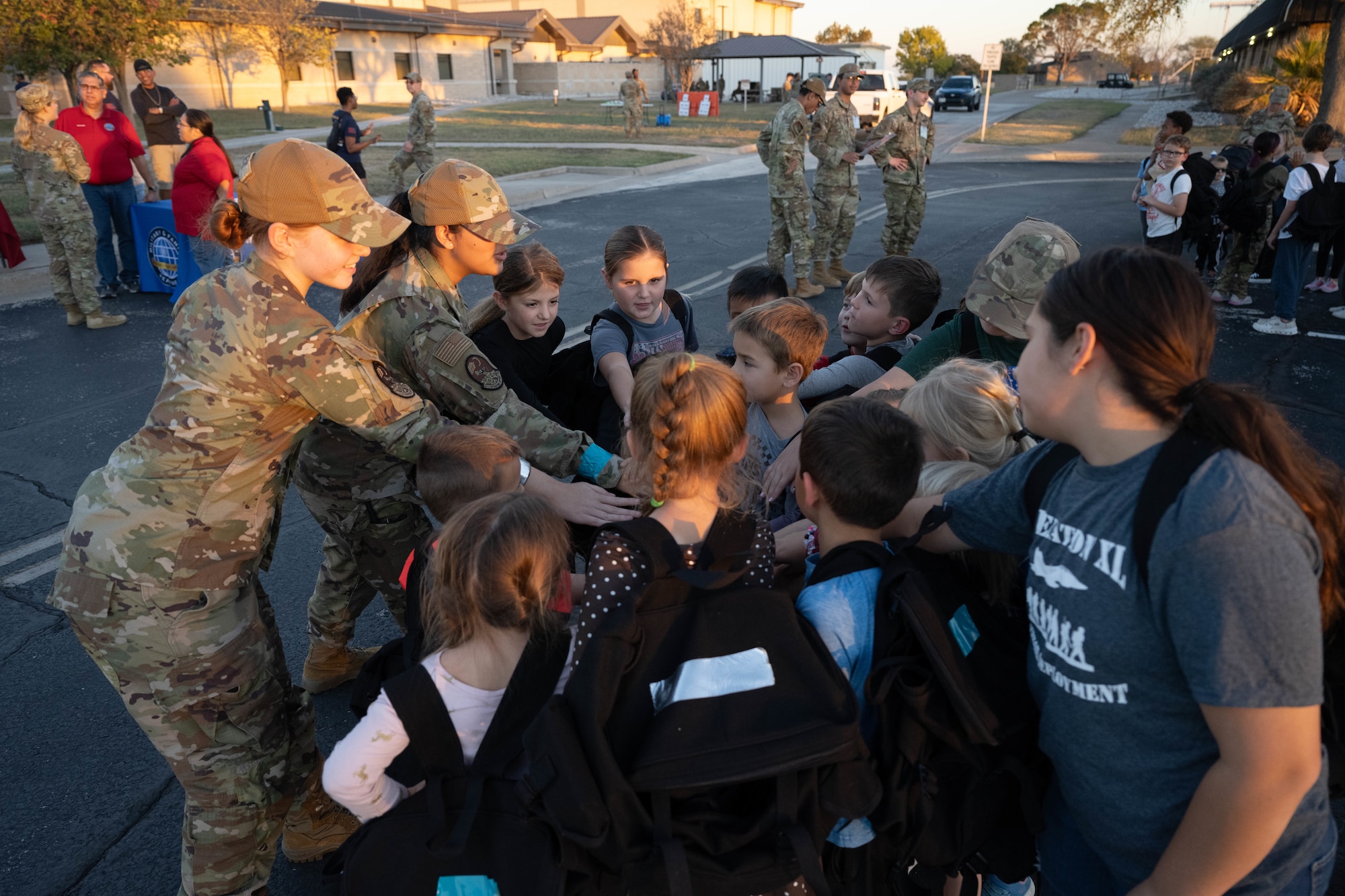 U.S. Air Force airmen from the 47th Operations Support Squadron (OSS) and Junior Deployment participants gather together in a group huddle during a Junior Deployment event at Laughlin Air Force Base, Texas, Nov. 21, 2025. The 47th OSS airmen served as group leaders for some participant groups. (U.S. Air Force photo by Airman 1st Class Darryl Keith)