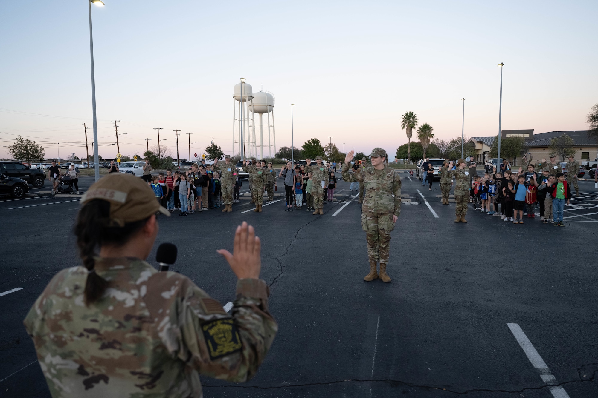 Airmen from the 47th Flying Training Wing and Junior Deployment participants simulate the oath of enlistment at Laughlin Air Force Base, Texas, Nov. 21, 2025. Participants and volunteers recited an oath of enlistment prior to beginning their mock deployment. (U.S. Air Force photo by Airman 1st Class Darryl Keith)