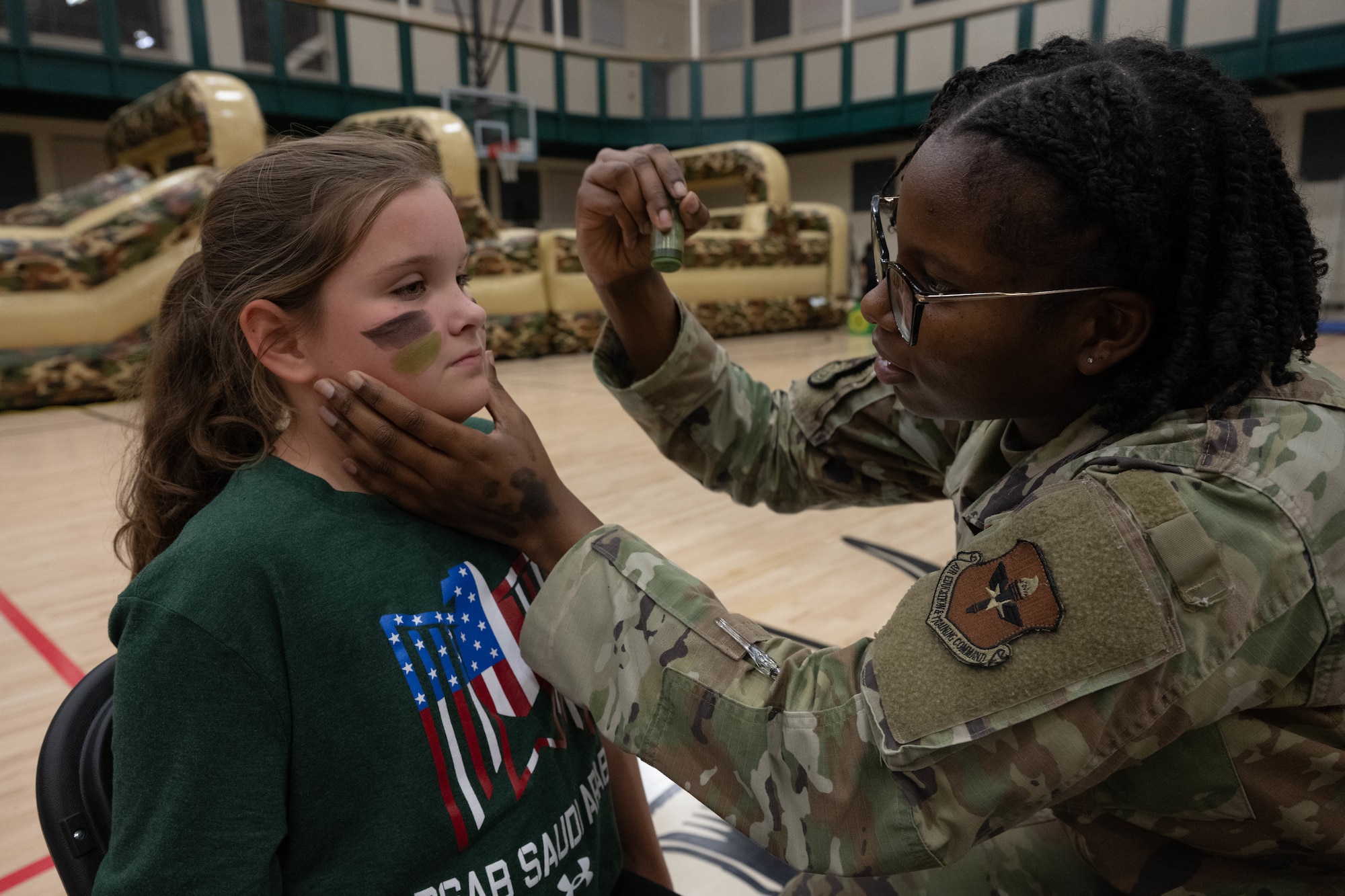 U.S. Air Force Airman 1st Class Sariekie Johnson, 47th Operations Support Squadron radar apprentice, applies face paint to a Junior Deployment participant during a Junior Deployment event at Laughlin Air Force Base, Texas, Nov. 21, 2025. Johnson painted participants’ faces before they went through an obstacle course. (U.S. Air Force photo by Airman 1st Class Darryl Keith)