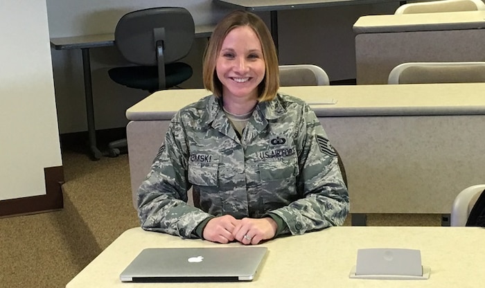 Airman smiles in front of computer.