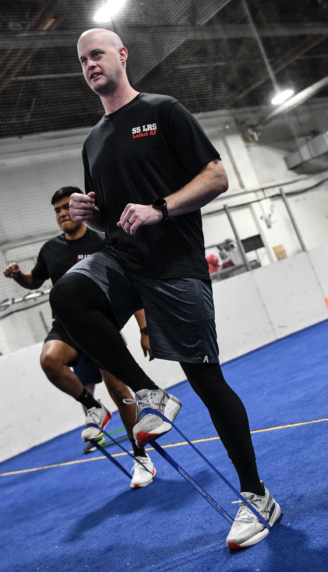 Master Sergeant Jordan Trick, 55th Logistics Readiness Squadron, does some leg stretches with bands at the Offutt Field House, December 12, 2025. (U.S. Air Force photo by Chad Watkins)
