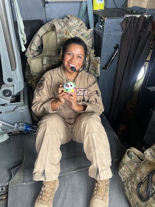 Airman poses with stuffed animal for photo.