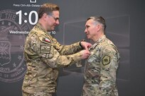 Polish Cyber Command leadership pins medal on Sixteenth Air Force leadership.