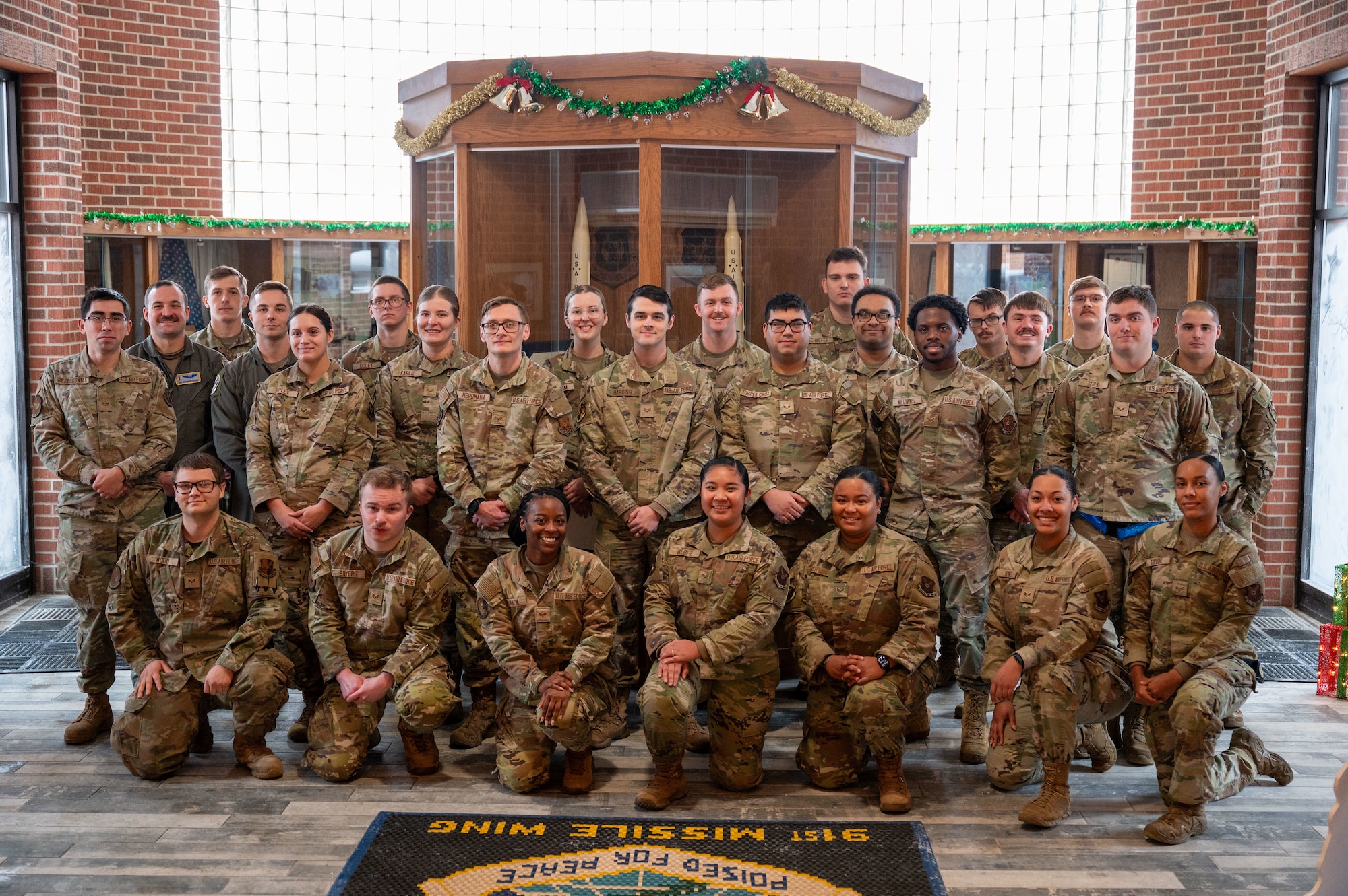 Airmen pose for a picture after graduating from the Professional Military Education (PME) Junior Enlisted Foundations Course 300 at Minot Air Force Base, North Dakota, Dec 11, 2025. The PME course was led by the 91st Operations Group focusing on Minot AFB's unique mission, technological advancements and intelligence briefs.
