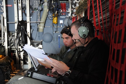 NAVAL AIR WEAPONS STATION CHINA LAKE, Calif. – In 2009, Ashton Engledow, back, current chief engineer of Battle Management System, participated in the first U.S. Special Operations Command and Battle Management System demonstration at China Lake. This event showcased a 10-shot BMS variant launched from an MC-130, which later evolved into the precision strike package and the AC-130W/AC-130J gunships. Engledow worked with the military operator, guiding him through the BMS operation. (NSWCDD Photo)