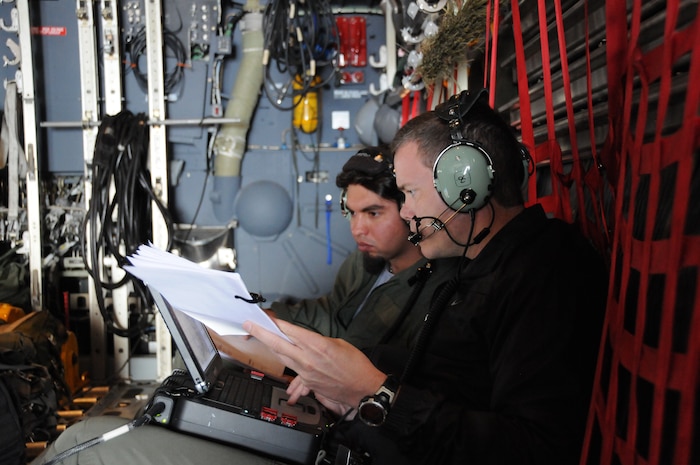 NAVAL AIR WEAPONS STATION CHINA LAKE, Calif. – In 2009, Ashton Engledow, back, current chief engineer of Battle Management System, participated in the first U.S. Special Operations Command and Battle Management System demonstration at China Lake. This event showcased a 10-shot BMS variant launched from an MC-130, which later evolved into the precision strike package and the AC-130W/AC-130J gunships. Engledow worked with the military operator, guiding him through the BMS operation. (NSWCDD Photo)