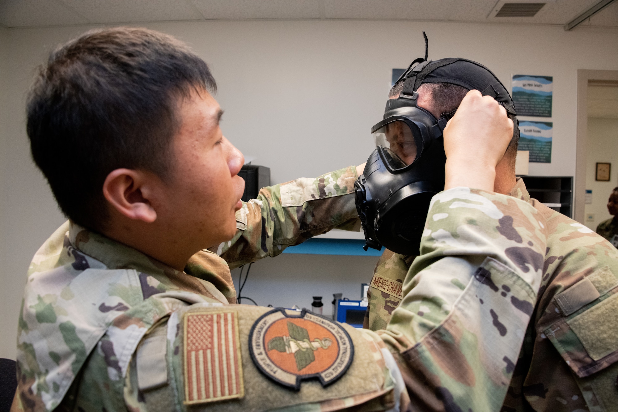 U.S. Air Force Airman 1st Class Yujin Song, a bioenvironmental engineering specialist assigned to the 42nd Operational Medical Readiness Squadron, seal-checks a mask with Tech. Sgt. Hector Mendez-Chavez, a bioenvironmental engineering specialist and flight chief assigned to the 42nd OMRS, at Maxwell Air Force Base, Alabama, June 6, 2025. The 42nd Medical Group consists of two squadrons: the 42nd Operational Medical Readiness Squadron and the 42nd Health Care Operations Squadron.  (U.S. Air Force photo by Neo B. Greene III)