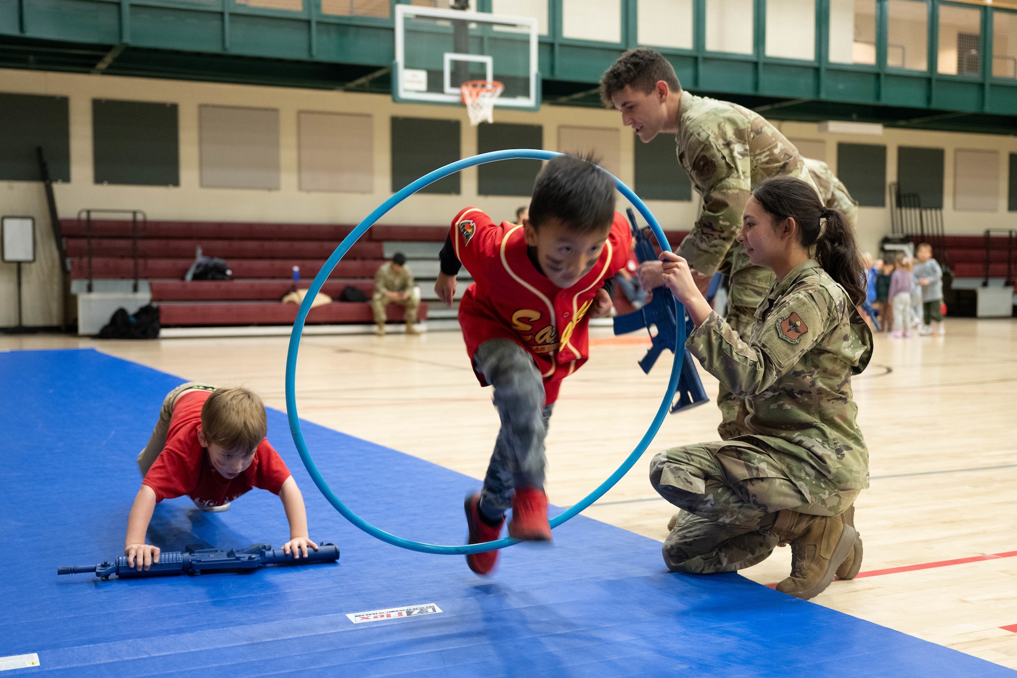 A Junior Deployment participant jumps through a hula hoop during a Junior Deployment event at Laughlin Air Force Base, Texas, Nov. 21, 2025. Participants ran through an obstacle course to simulate physical training and its importance for military members. (U.S. Air Force photo by Airman 1st Class Darryl Keith)