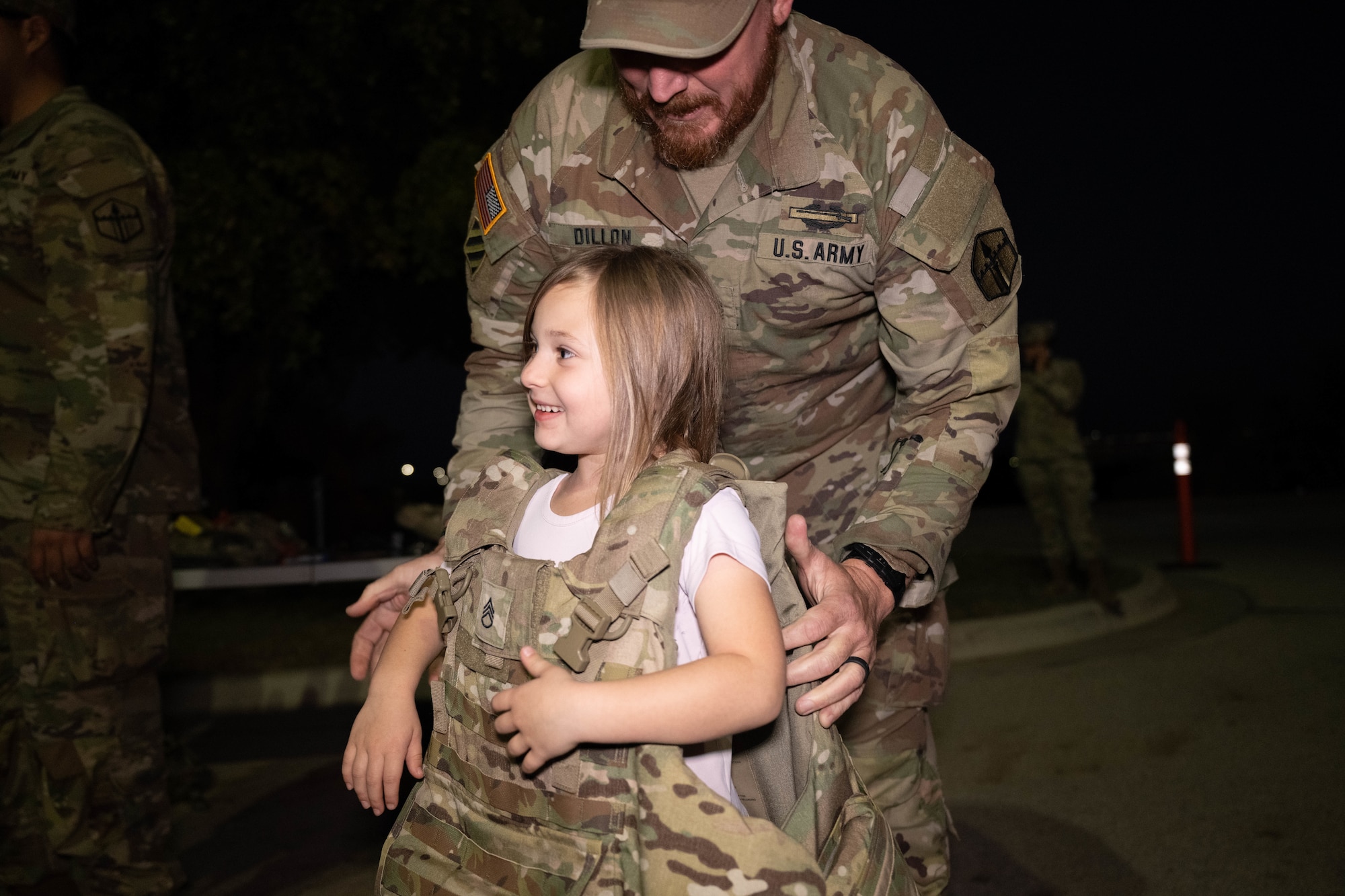 A U.S. Army soldier places a body armor vest on a Junior Deployment participant during a Junior Deployment event at Laughlin Air Force Base, Texas, Nov. 21, 2025. Laughlin held the event to educate children of military members about deployments to decrease separation anxiety. (U.S. Air Force photo by Airman 1st Class Darryl Keith)