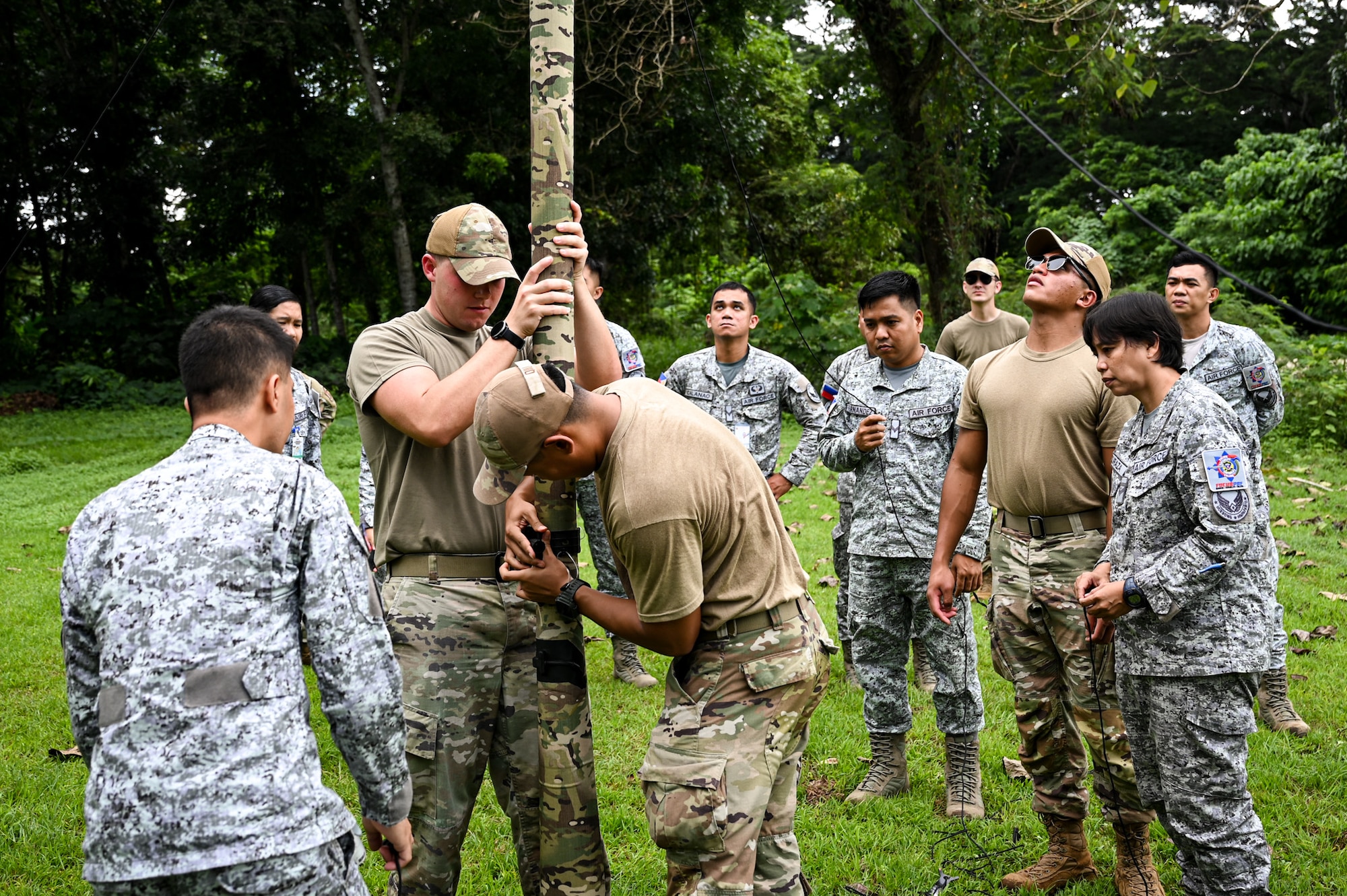 A team of U.S. Air Force Airmen and Philippine Air Force Airmen work together to set up a radio antenna during hands-on subject matter expert exchange training between 11th Air Task Force and PAF members at Antonio Bautista Air Base, Philippines, Oct. 22, 2025.