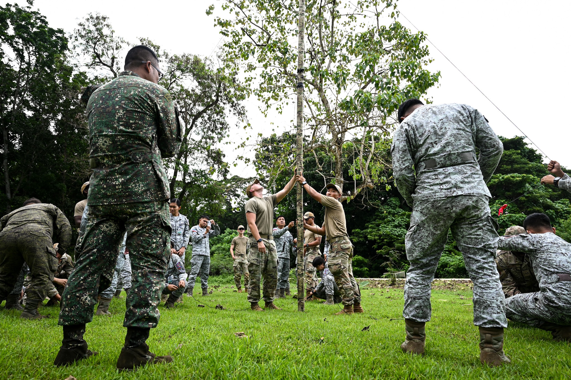 U.S. Air Force Senior Airman Kyle Haynes and Airman 1st Class Daniel Qiu, 11th Combat Air Base Squadron radio-frequency technicians, hold up a radio transmitter during the hands-on portion of the subject matter expert exchange at Antonio Bautista Air Base, Philippines, Oct. 22, 2025.