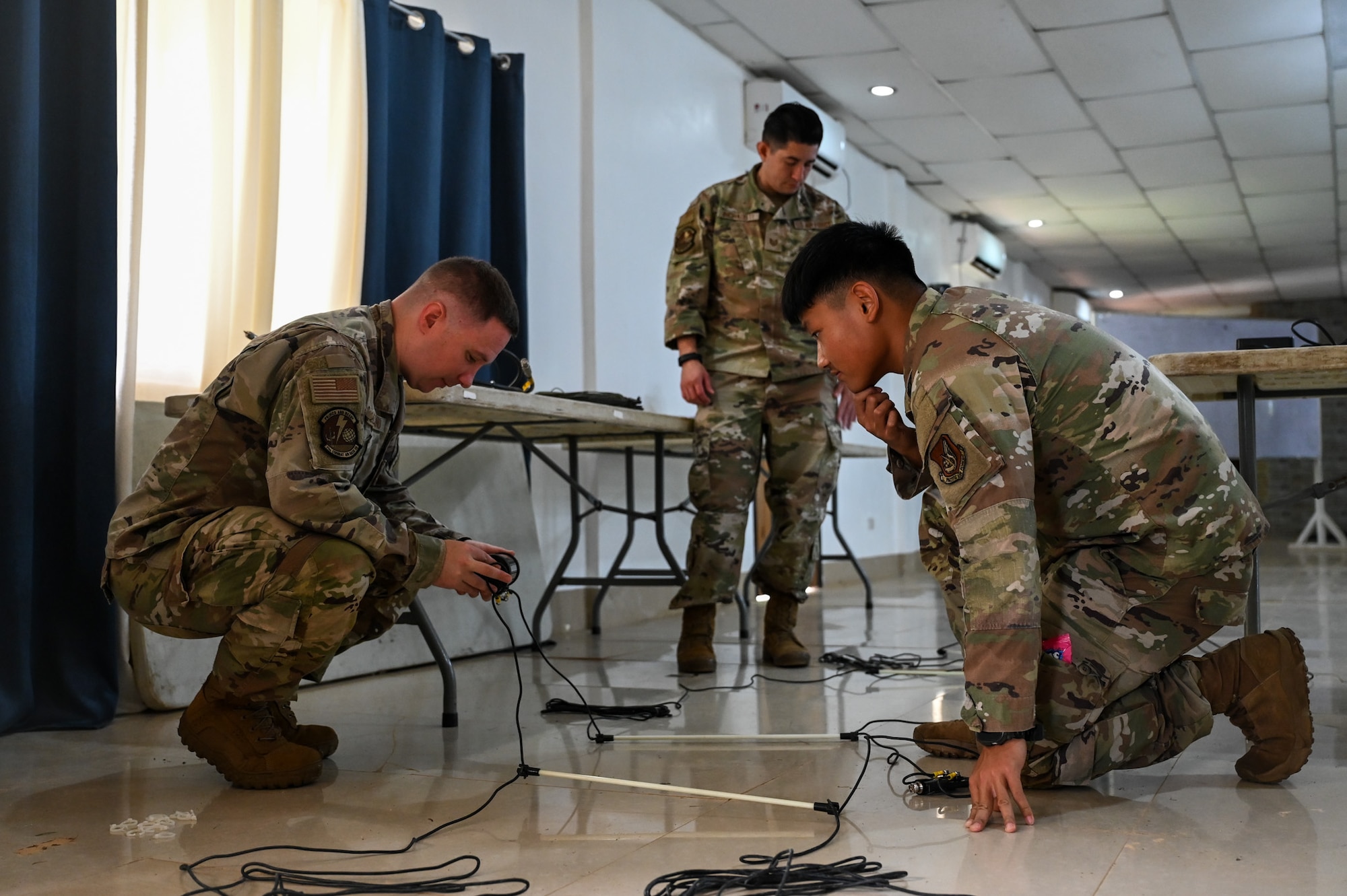 U.S. Air Force Staff Sgt. Sean Gilliland, 11th Combat Air Base Squadron radio frequency transmissions systems supervisor, and Airman 1st Class Daniel Qiu, 11th CABS radio-frequency technician, perform a test on communications equipment before leading the hands-on portion of the subject matter expert exchange at Antonio Bautista Air Base, Philippines, Oct. 22, 2025.