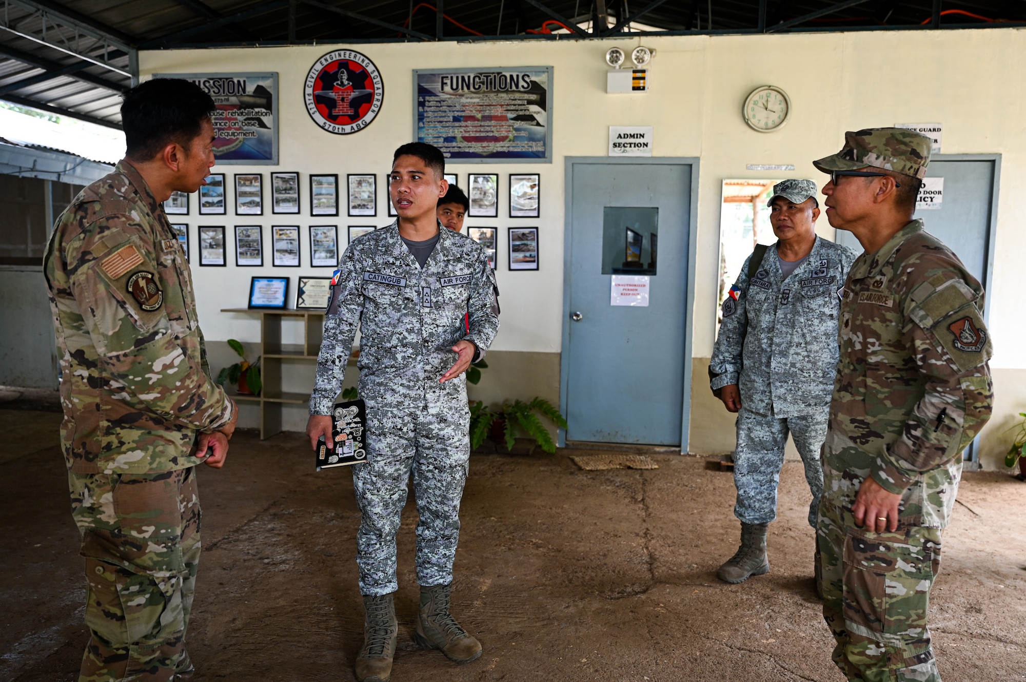 Two U.S. Air Force Airmen from the 11th Combat Air Base Squadron speak to two Philippine Air Force members during a tour of the 573rd Civil Engineering Squadron at Antonio Bautista Air Base, Philippines, Oct. 21, 2025.