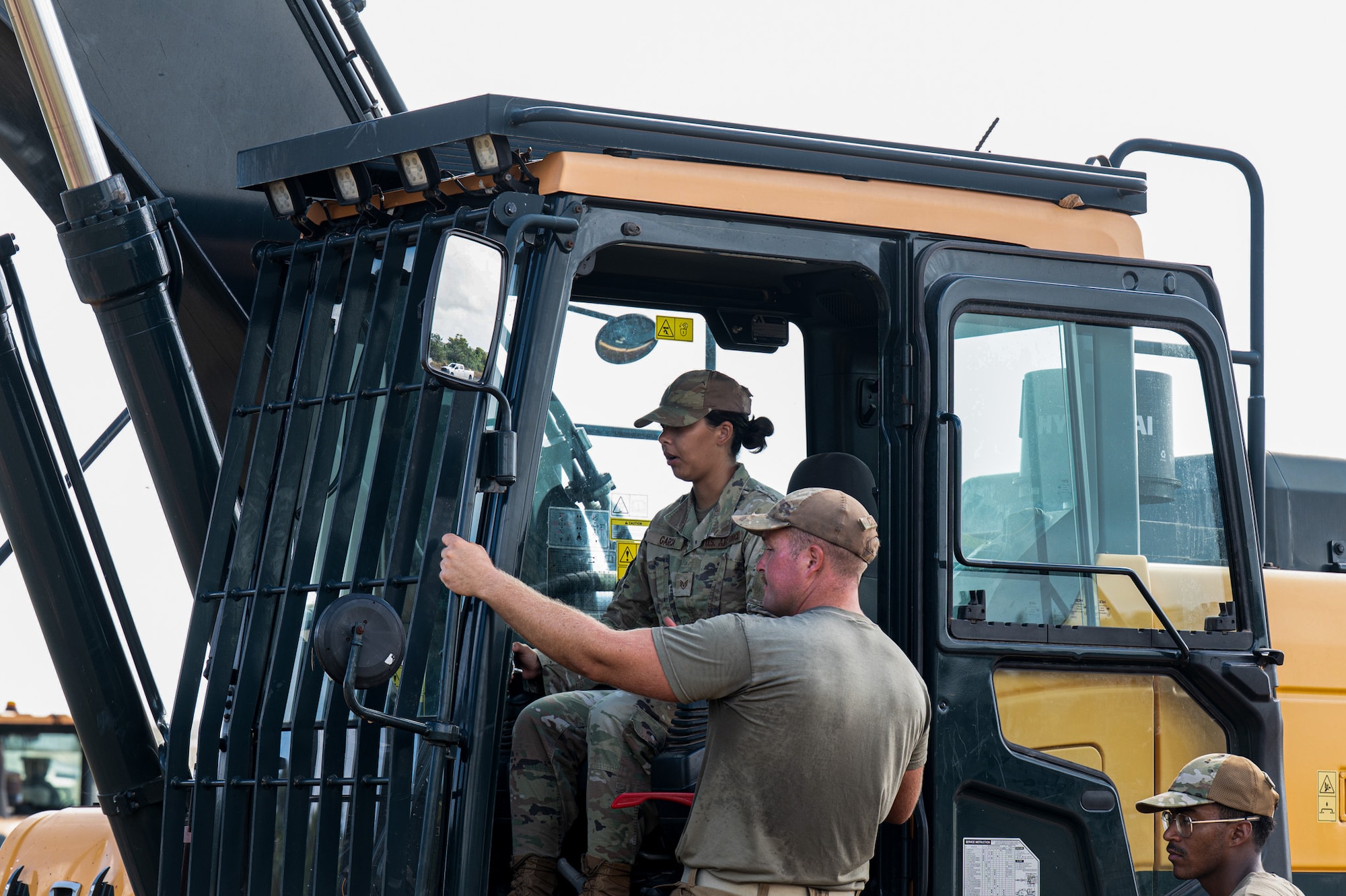 U.S. Air Force Staff Sgt. Natasha Garcia, 11th Air Task Force junior executive to the command chief, learns about an excavator vehicle assigned to the 36th Civil Engineer Squadron, while supervised by civil engineering heavy machine operators at Andersen Air Force Base on Nov. 17, 2025.