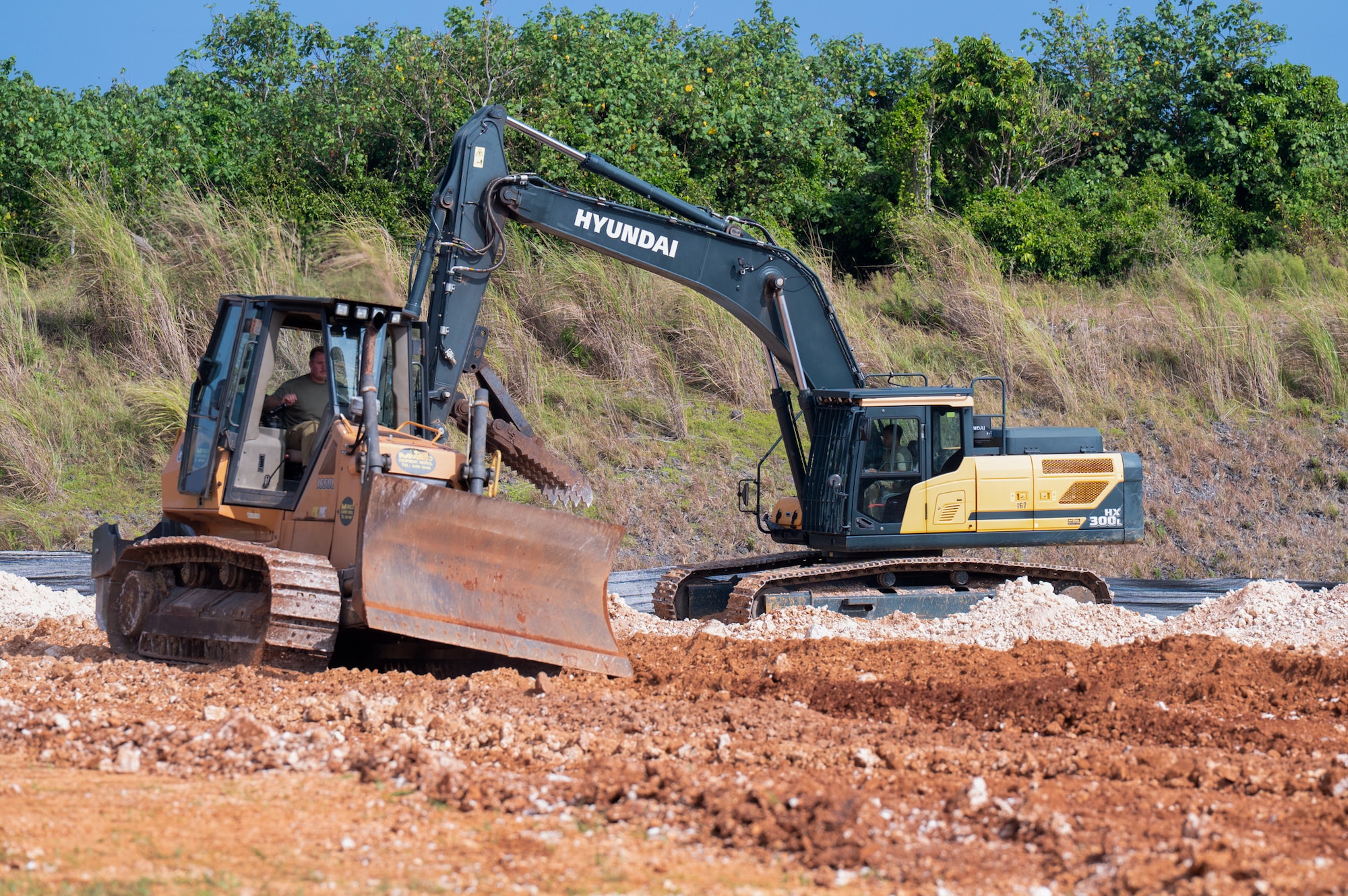 U.S. Air Force Airmen to the 36th Civil Engineer Squadron and the 11th Combat Air Base Squadron operate a bulldozer and excavator, removing debris from a construction site at Andersen Air Force Base on Nov. 18, 2025.