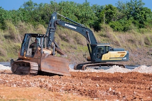 U.S. Air Force Airmen to the 36th Civil Engineer Squadron and the 11th Combat Air Base Squadron operate a bulldozer and excavator, removing debris from a construction site at Andersen Air Force Base on Nov. 18, 2025.