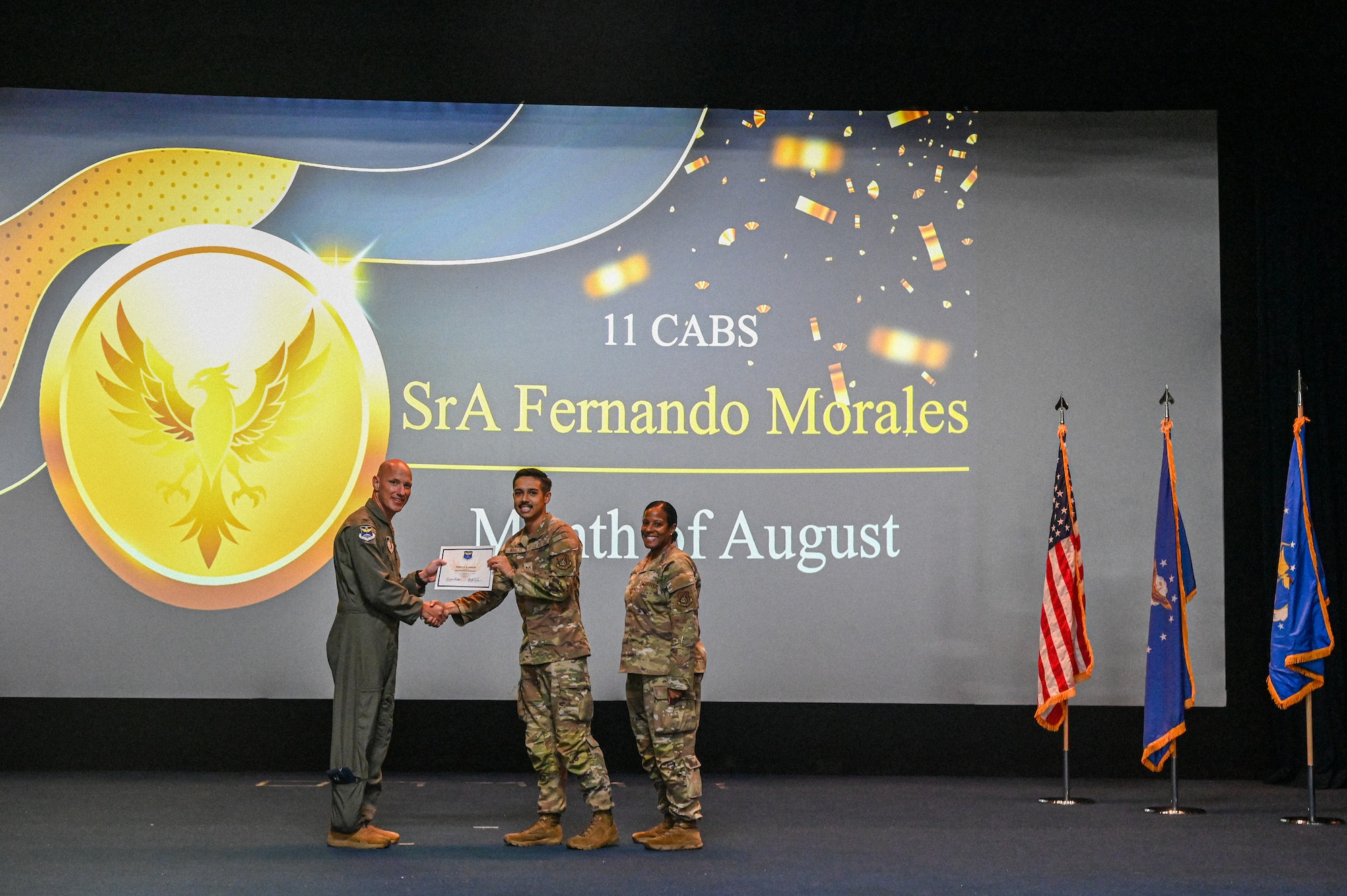 U.S. Air Force Col. Brett Cassidy, commander of the 11th Air Task Force, presents Senior Airman Fernando Morales, 11th Combat Air Base Squadron, the Phoenix Award for August during the 11th ATF Third Quarter Award Ceremony at Andersen Air Force Base on Oct. 28, 2025.