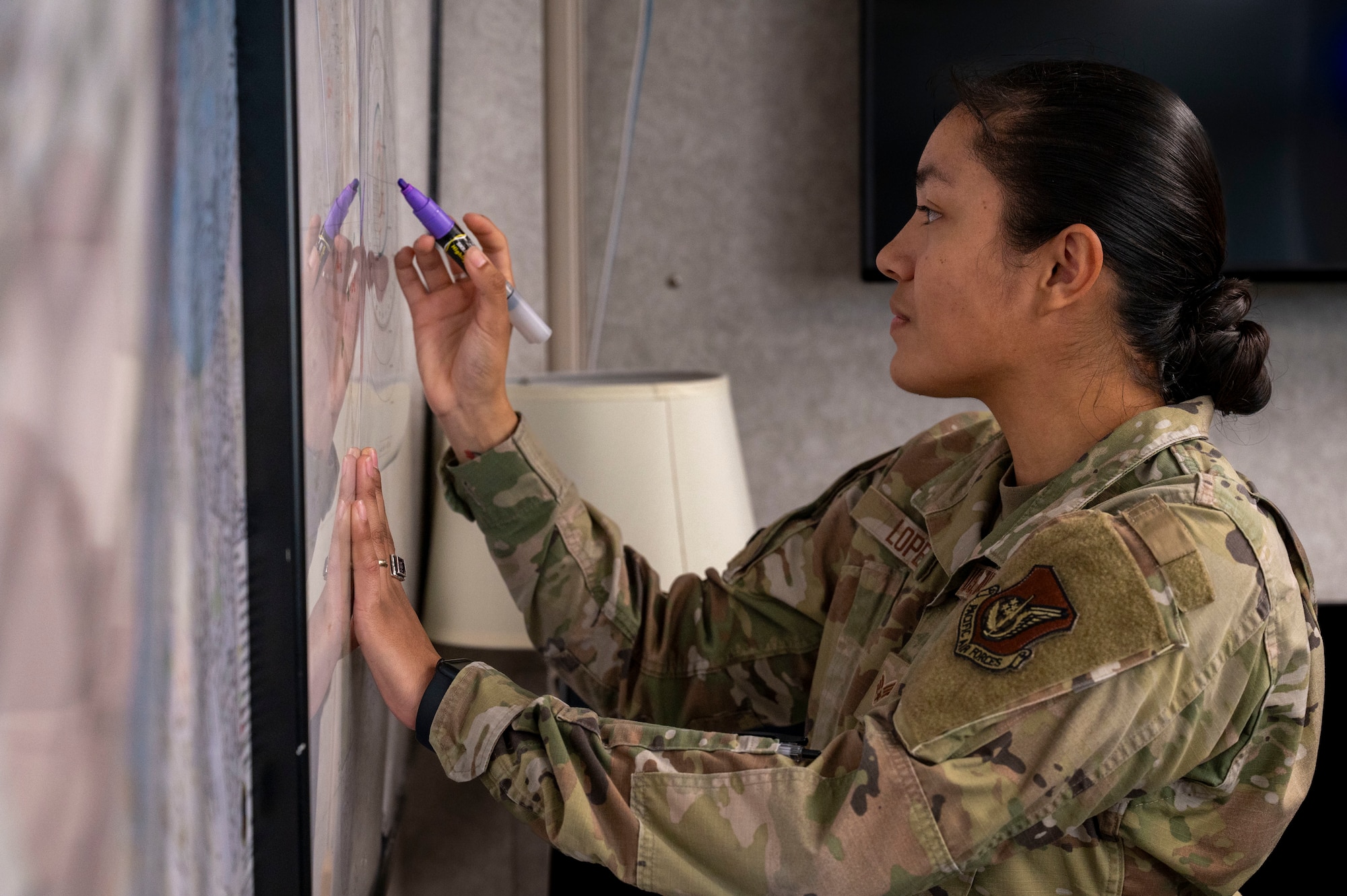 U.S. Air Force Senior Airman Nayeli Lopez, 18th Operational Support Squadron airfield management journeyman, reviews airspace at Kadena Air Base, Japan, Dec. 11, 2025.
