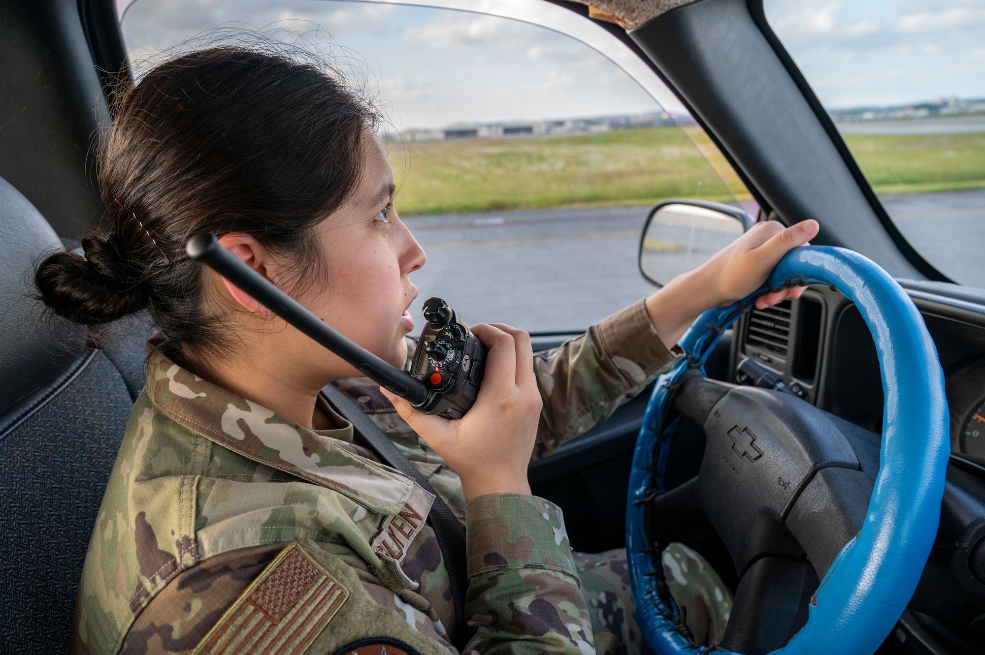 U.S. Air Force Senior Airman Dana Nguyen, 18th Operational Support Squadron airfield management shift lead, uses a land mobile radio during a foreign object debris check on the flight line at Kadena Air Base, Japan, Dec. 11, 2025.