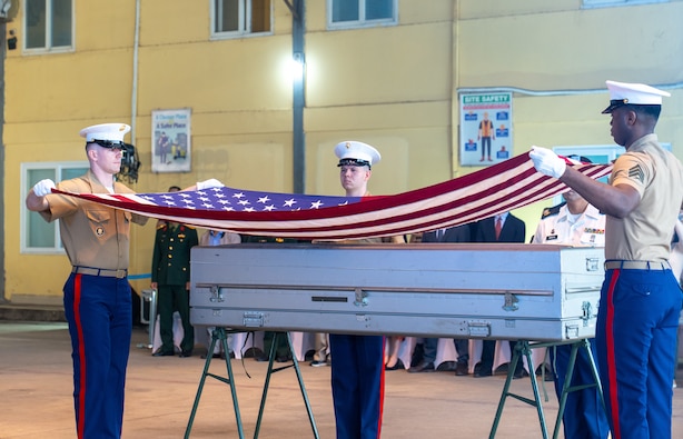 Two members of the U.S. Marine Corps. prepare to drape an American flag over a transport case that contains potential U.S. service member remains during the 171st Repatriation Ceremony at the Gia Lam Airfield, Hanoi, Vietnam, on Dec. 13, 2025.