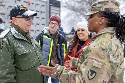 Command Sgt. Maj. Joy L. Allen, U.S. Army Financial Management Command senior enlisted advisor, right, talks with Retired U.S. Army Sgt. Maj. Bruce Paul, who served as a finance Soldier, as Kelly and Levi Orders-Woempner listen during a Wreaths Across America event at Crown Hill Cemetery in Indianapolis Dec. 13, 2025. This year, more than two million volunteers and supporters gathered to remember, honor and teach by laying wreaths on the graves of veterans at more than 5,200 participating locations in all 50 states, at sea and abroad. (U.S. Army photo by Mark R. W. Orders-Woempner)