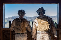 U.S. Marine Corps Sgt. Moses Vukaj, left, a joint terminal attack controller, and Staff Sgt. Zackary Oneal, a JTAC evaluator, both with Fire Support Battalion, 11th Marine Regiment, 1st Marine Division, observe close air support during Exercise Steel Knight 25 at Marine Corps Base Camp Pendleton, California, Dec. 9, 2025. The integration demonstrates how JTAC operators and H-1 helicopter crews synchronize fires and maneuver, enabling accurate and timely CAS for Marines on the ground. Steel Knight is an annual exercise that strengthens the Navy-Marine Corps team's ability to respond forward, integrate across domains, and sustain Marine Air-Ground Task Force readiness. Vukaj is a native of Washington. O’Neal is a native of California. (U.S. Marine Corps photo by Lance Cpl. Mia Ocampo)