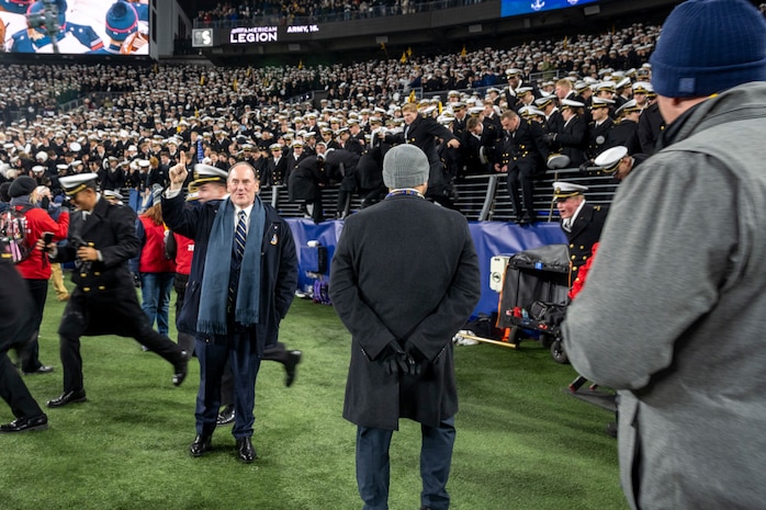 BALTIMORE (Dec. 13, 2025) - A Naval Criminal Investigative Service Special Agent, assigned to the Protective Services Field Office, provides specialized security for the Honorable John C. Phelan, Secretary of the Navy, during the 126th Army-Navy game at MT&T Stadium in Baltimore, Dec. 13, 2025. NCIS protective operations agents specialize in protective operations, and are specifically trained to anticipate dangers, plan safe escape routes, and respond instantly. (U.S. Navy photo by Mass Communication Specialist 2nd Class Kaitlyn E. Eads)
