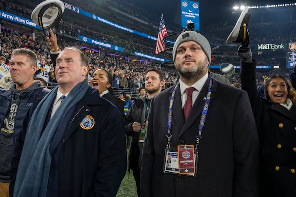 BALTIMORE (Dec. 13, 2025) - A Naval Criminal Investigative Service Special Agent, assigned to the Protective Services Field Office, provides close security for Honorable John C. Phelan, Secretary of the Navy, under the executive protection coverage during the 126th Army-Navy game at MT&T Stadium in Baltimore, Dec. 13, 2025. NCIS protective operations agents specialize in protective operations, and are specifically trained to anticipate dangers, plan safe escape routes, and respond instantly. (U.S. Navy photo by Mass Communication Specialist 2nd Class Kaitlyn E. Eads)
