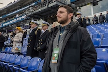 BALTIMORE (Dec. 13, 2025) - A Naval Criminal Investigative Service Special Agent, assigned to the Protective Services Field Office, ensures the safety of Chief of Naval Operations Adm. Daryl Caudle under the executive protection coverage during the 126th Army-Navy game at MT&T Stadium in Baltimore, Dec. 13, 2025. NCIS protective operations agents specialize in protective operations, and are specifically trained to anticipate dangers, plan safe escape routes, and respond instantly. (U.S. Navy photo by Mass Communication Specialist 2nd Class Kaitlyn E. Eads)