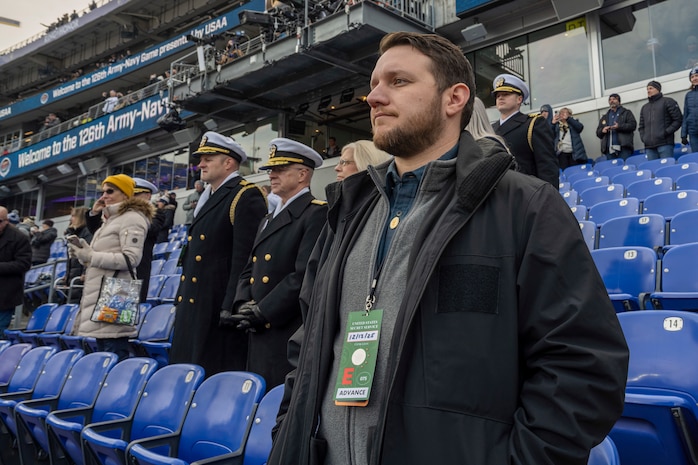 BALTIMORE (Dec. 13, 2025) - A Naval Criminal Investigative Service Special Agent, assigned to the Protective Services Field Office, ensures the safety of Chief of Naval Operations Adm. Daryl Caudle under the executive protection coverage during the 126th Army-Navy game at MT&T Stadium in Baltimore, Dec. 13, 2025. NCIS protective operations agents specialize in protective operations, and are specifically trained to anticipate dangers, plan safe escape routes, and respond instantly. (U.S. Navy photo by Mass Communication Specialist 2nd Class Kaitlyn E. Eads)