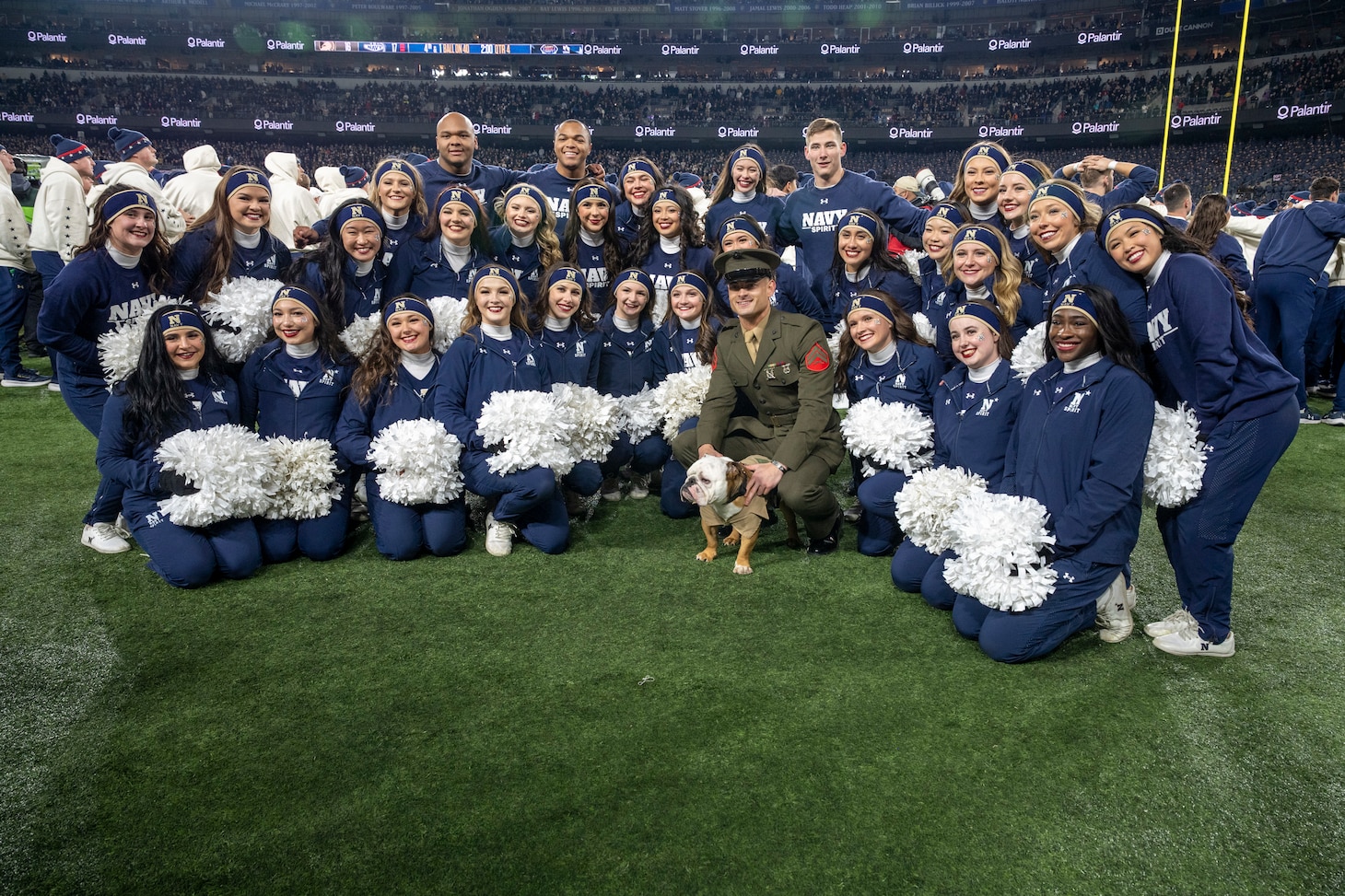 BALTIMORE (Dec. 13, 2025) - Marine Corps Mascot poses with United States Naval Academy cheerleaders during the 126th Army-Navy game at MT&T Stadium in Baltimore, Md., Dec. 13, 2025. (U.S. Navy photo by Mass Communication Specialist 2nd Class Kaitlyn E. Eads)