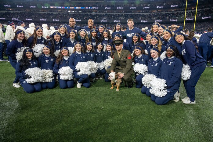 BALTIMORE (Dec. 13, 2025) - Marine Corps Mascot poses with United States Naval Academy cheerleaders during the 126th Army-Navy game at MT&T Stadium in Baltimore, Md., Dec. 13, 2025. (U.S. Navy photo by Mass Communication Specialist 2nd Class Kaitlyn E. Eads)