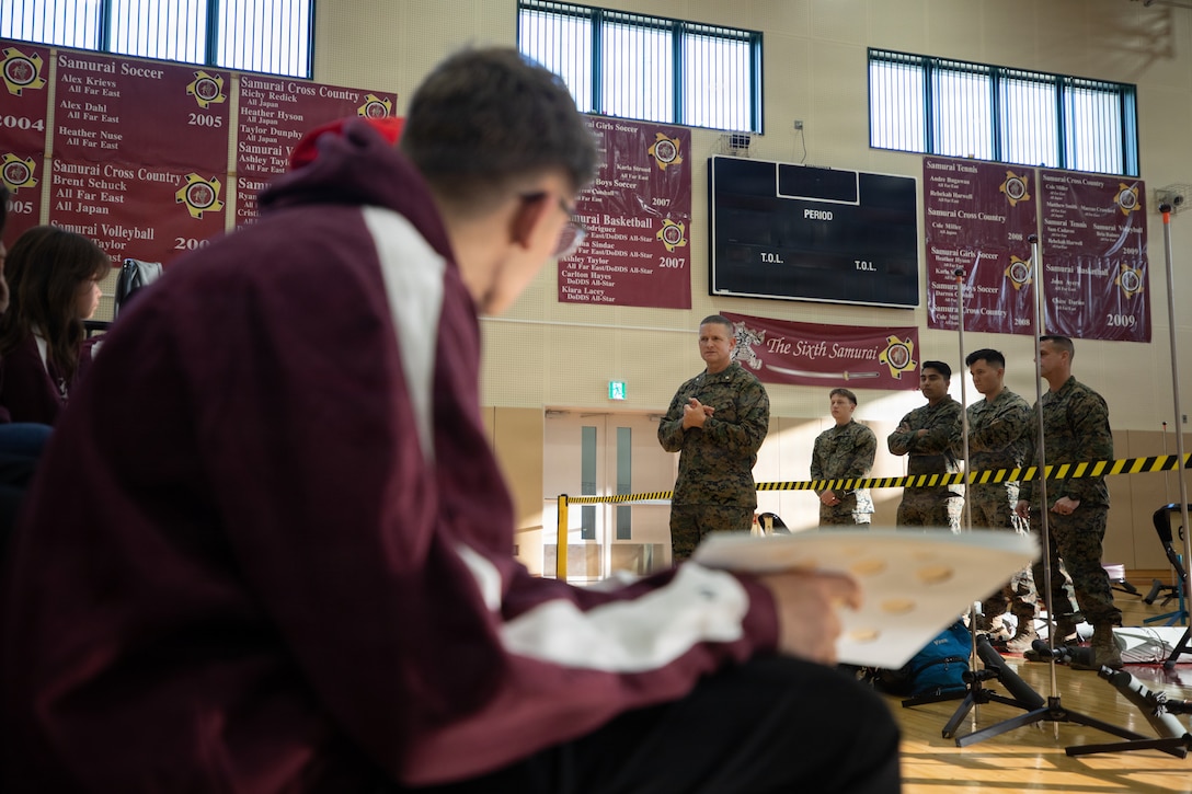 Retired U.S. Marine Corps Lt. Col. Michael Kelley, senior Marine instructor, Matthew C. Perry High School Marine Corps Junior Reserve Officers’ Training Corps, gives a safety brief to JROTC cadets before an air rifle marksmanship competition at Matthew C. Perry High School, Marine Corps Air Station Iwakuni, Japan, Dec. 5, 2025. Cadets from five Department of Defense Education Activity high schools across the Pacific met at MCAS Iwakuni to hone their marksmanship skills in a friendly competition. (U.S. Marine Corps photo by Cpl. Colin Thibault)