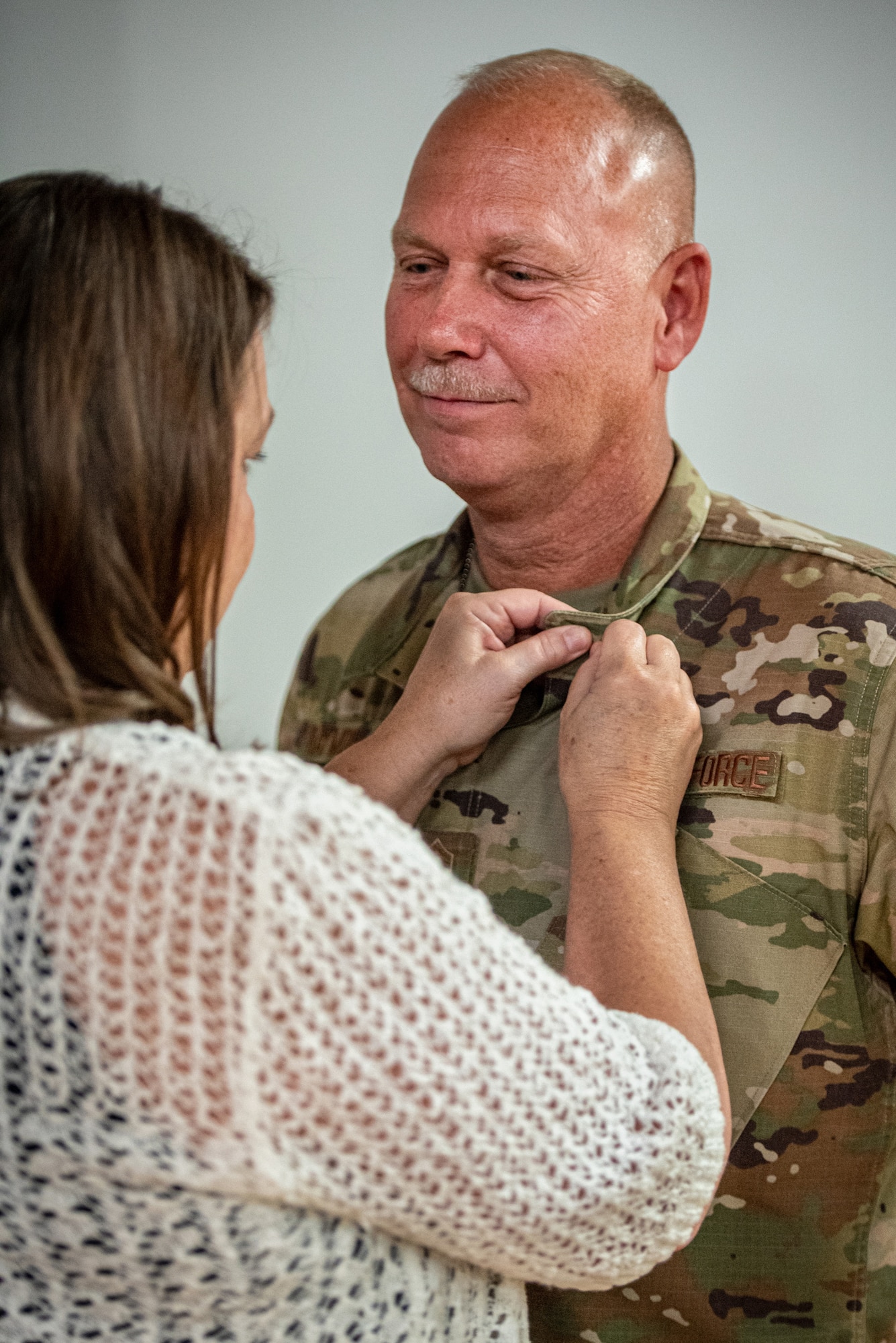 Chief Master Sgt. Krome Raymond, senior enlisted leader for the 123rd Mission Support Group, accepts a retirement pin during his retirement ceremony at the Kentucky Air National Guard Base in Louisville, Ky., Sept. 7, 2025. Raymond served 22 years in both the active-duty Air Force and Kentucky Air Guard during three periods of enlistment spread over 38 years. (U.S. Air National Guard photo by Senior Airman Annaliese Billings)