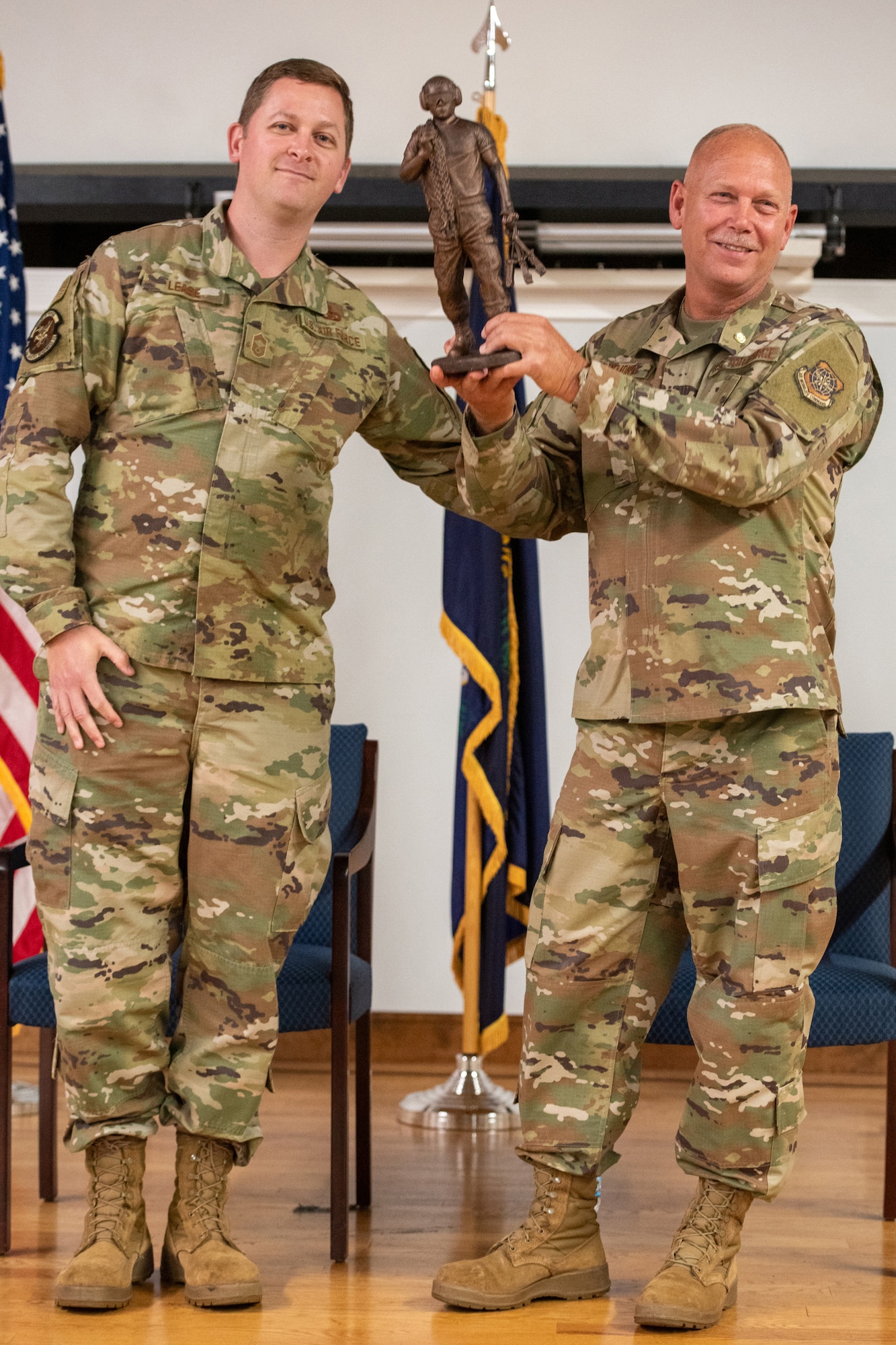 Chief Master Sgt. Patrick Lease, aerial port superintendent for the 123rd Logistics Readiness Squadron, presents Chief Master Sgt. Krome Raymond, senior enlisted leader for the 123rd Mission Support Group, with a token of appreciation during Raymond’s retirement ceremony at the Kentucky Air National Guard Base in Louisville, Ky., Sept. 7, 2025. Raymond served 22 years in both the active-duty Air Force and Kentucky Air Guard during three periods of enlistment spread over 38 years. (U.S. Air National Guard photo by Senior Airman Annaliese Billings)