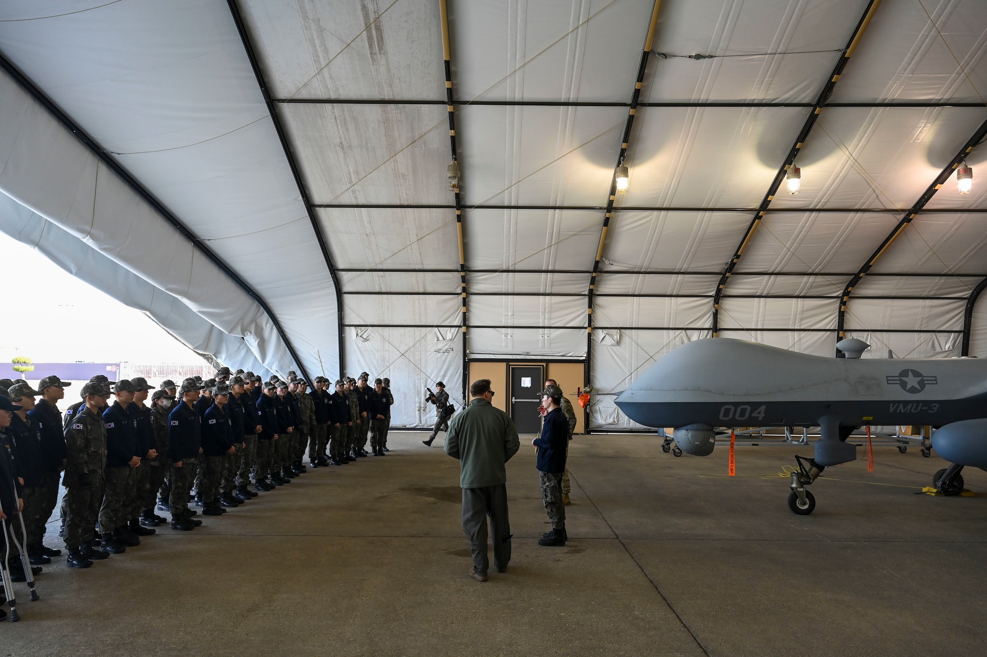 Men speak to a group of people.